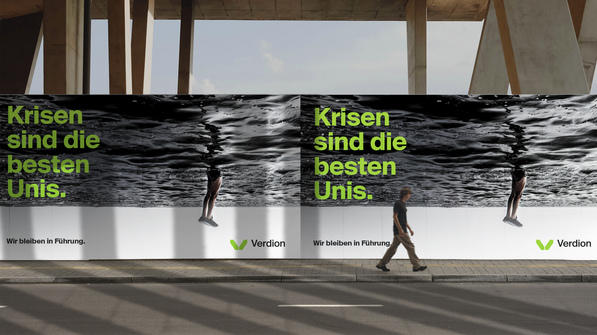 Outdoor billboard advertisement for Verdion, featuring a striking black and white image of a person reflected in rippling water, creating an illusion of being upside down. The bold green text reads 'Krisen sind die besten Unis.' (Crises are the best universities.), with the tagline 'Wir bleiben in Führung.' (We stay ahead.) A pedestrian walks past the billboard, which is set against a modern architectural backdrop.